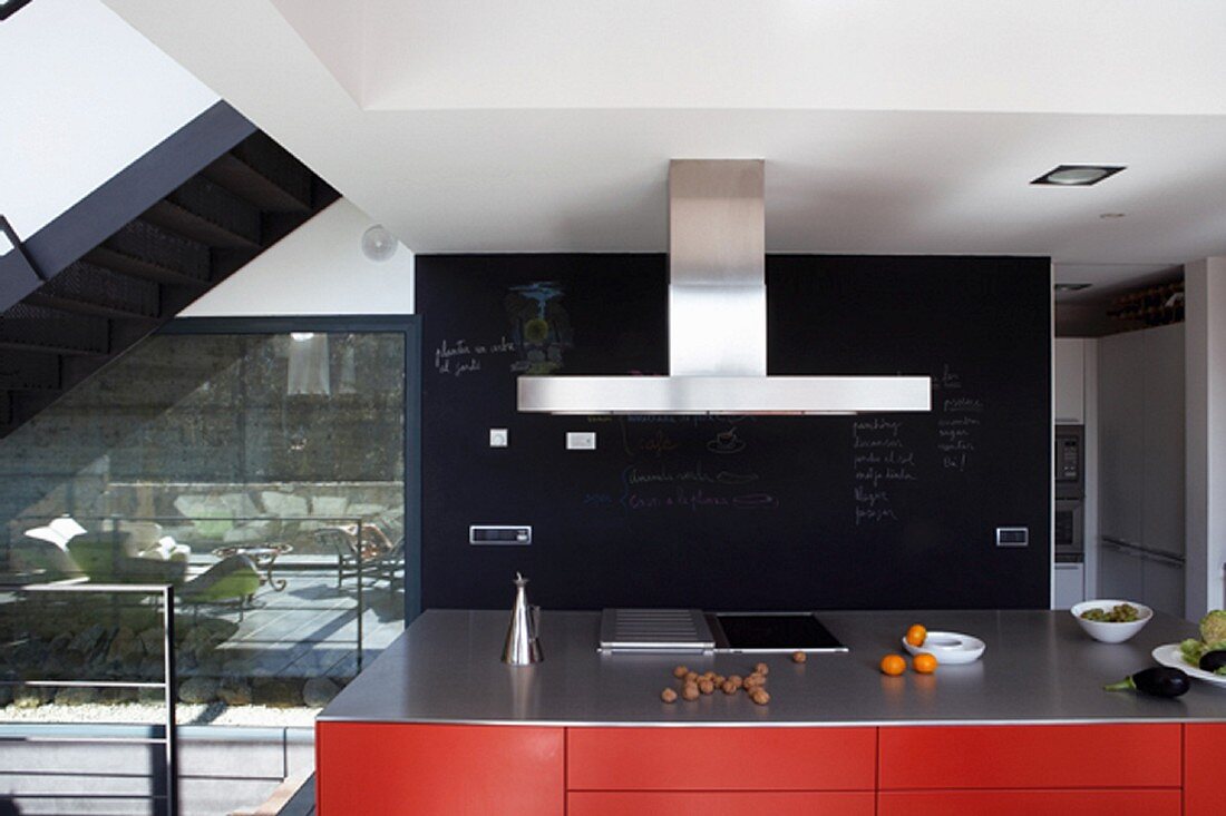 Red kitchen island in front of black slate wall panel