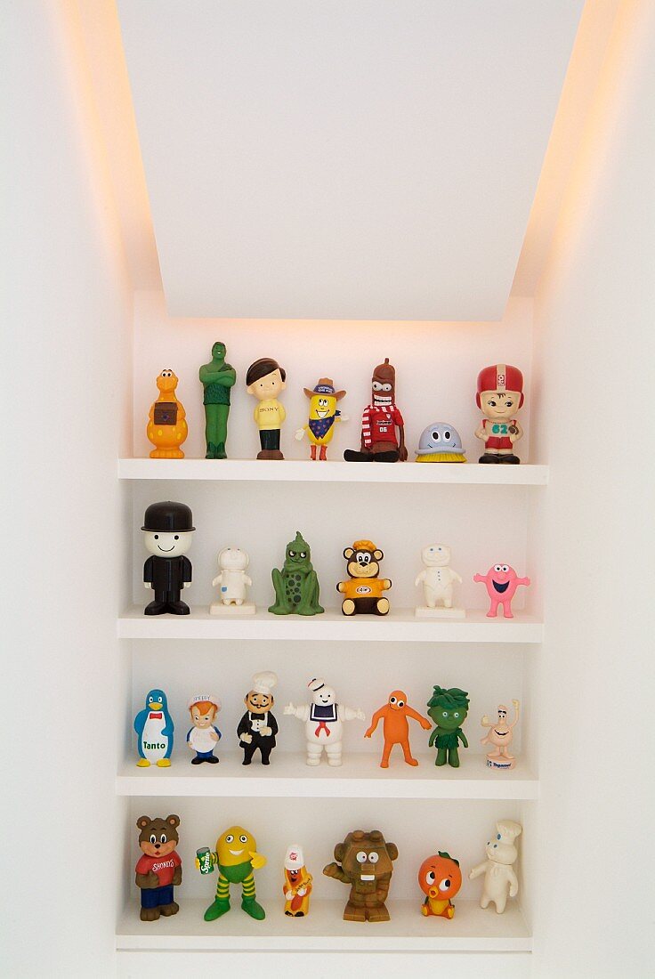 Plastikfiguren auf Regal in Nische mit indirekter Beleuchtung