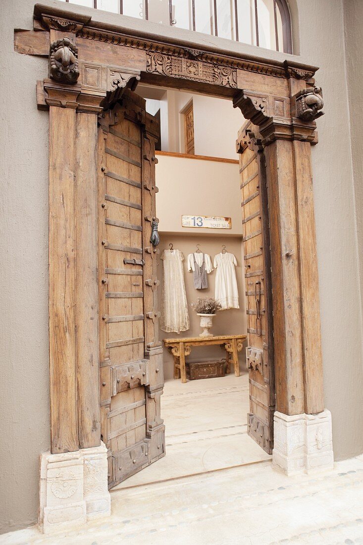 Open, heavy wooden door with iron fittings