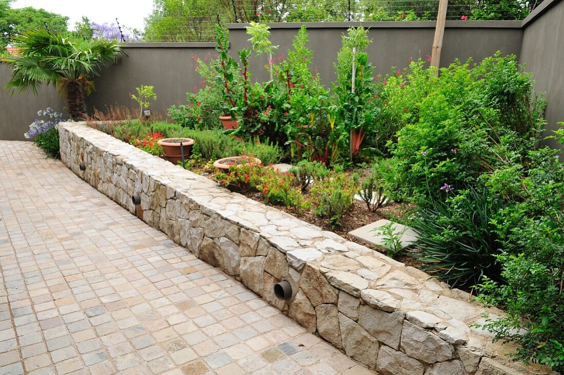 Raised bed edged by stone wall