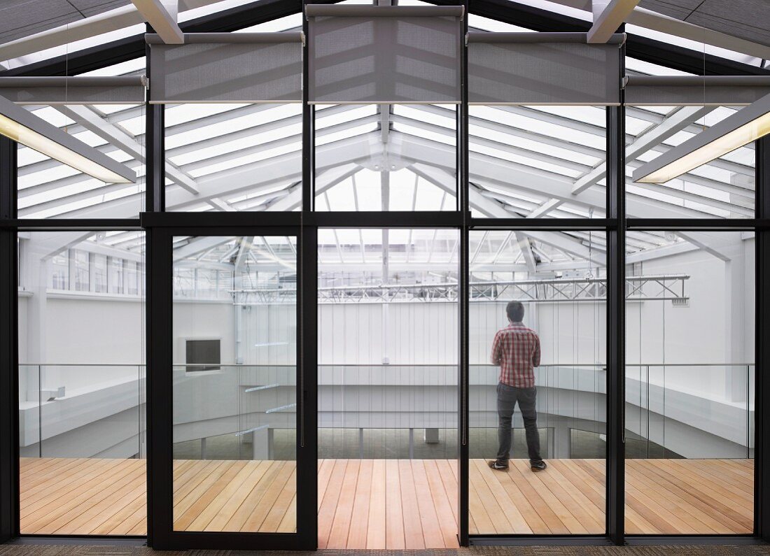 Modernes Bürogebäude mit umlaufender Galerie und Dach mit Glasstahlkonstruktion