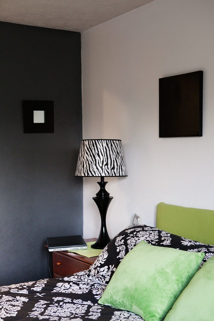 Zebra-patterned bedside lamp in corner of bedroom