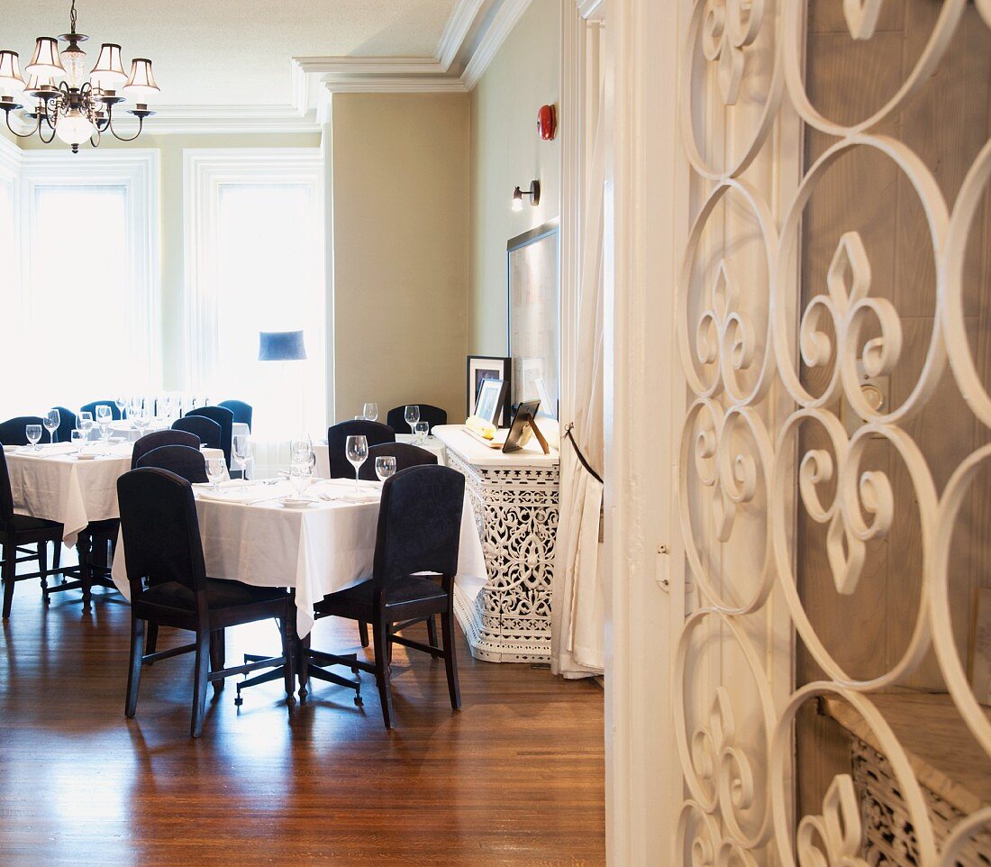 Elegant hotel restaurant with white wrought iron gate and parquet floor of exotic wood