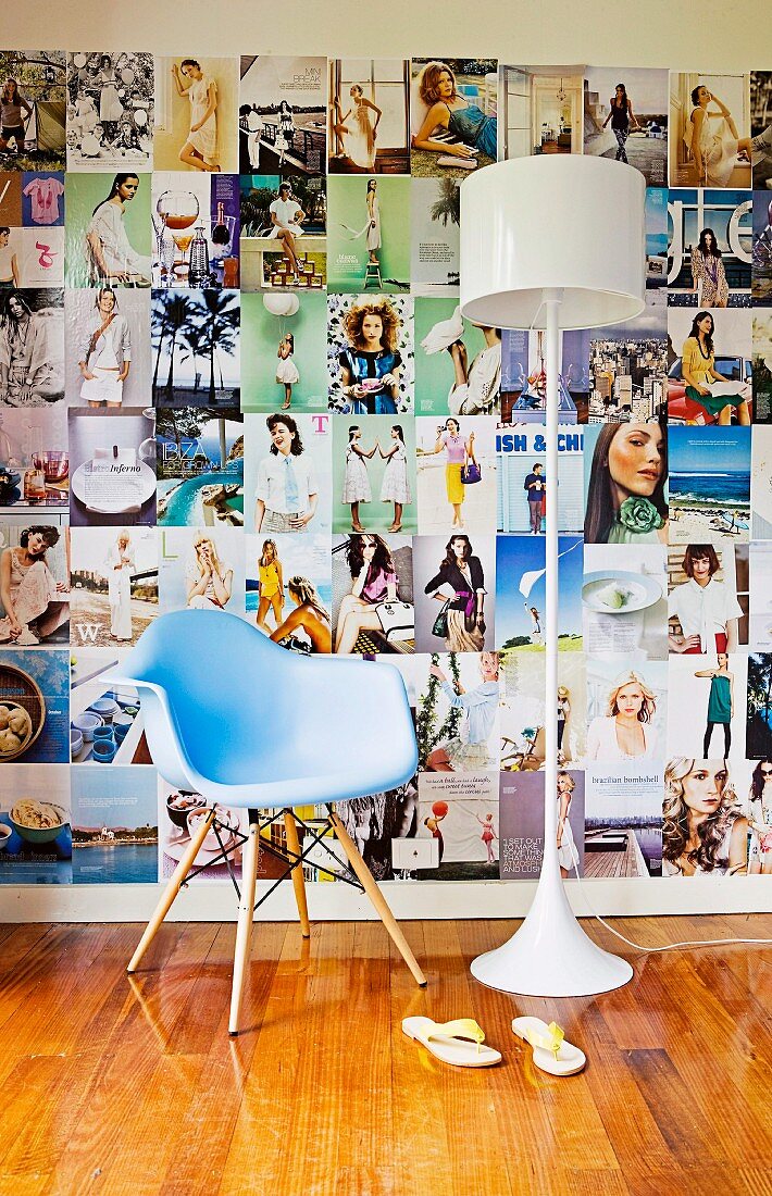 Pastellblauer Designerstuhl und weiße Retro-Lampe vor großer Wand-Collage