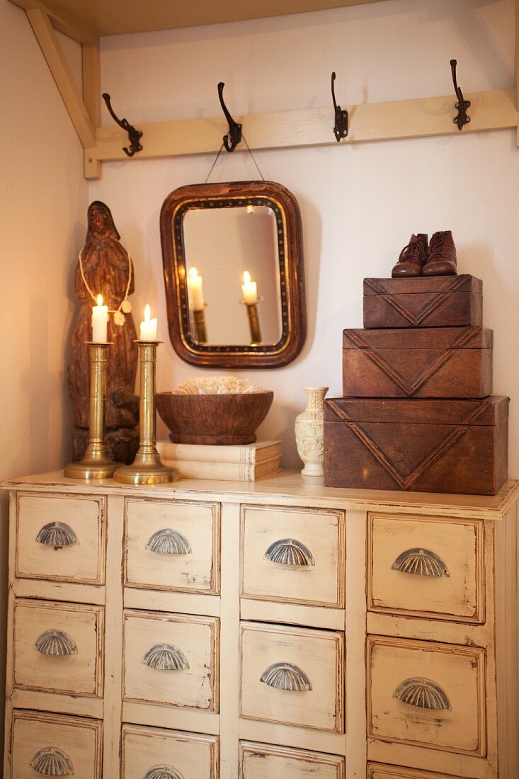 Candlesticks & wooden ornaments on apothecary cabinet