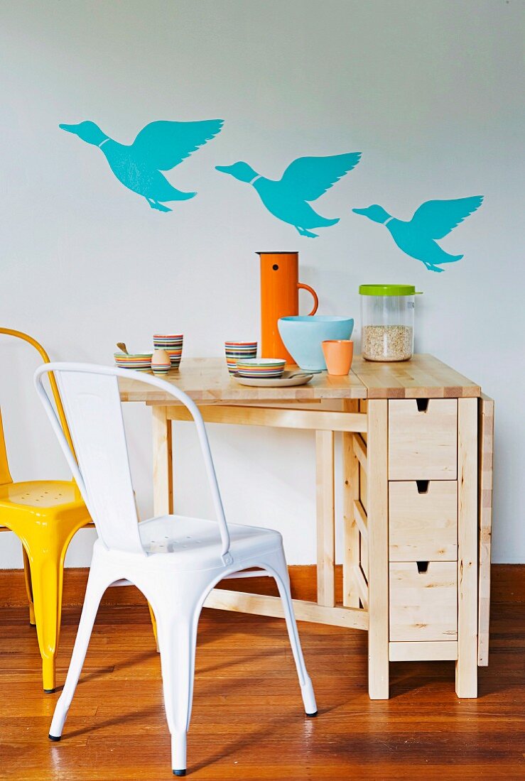 Hinged, space-saving wooden table with small drawers; three flying ducks on the wall