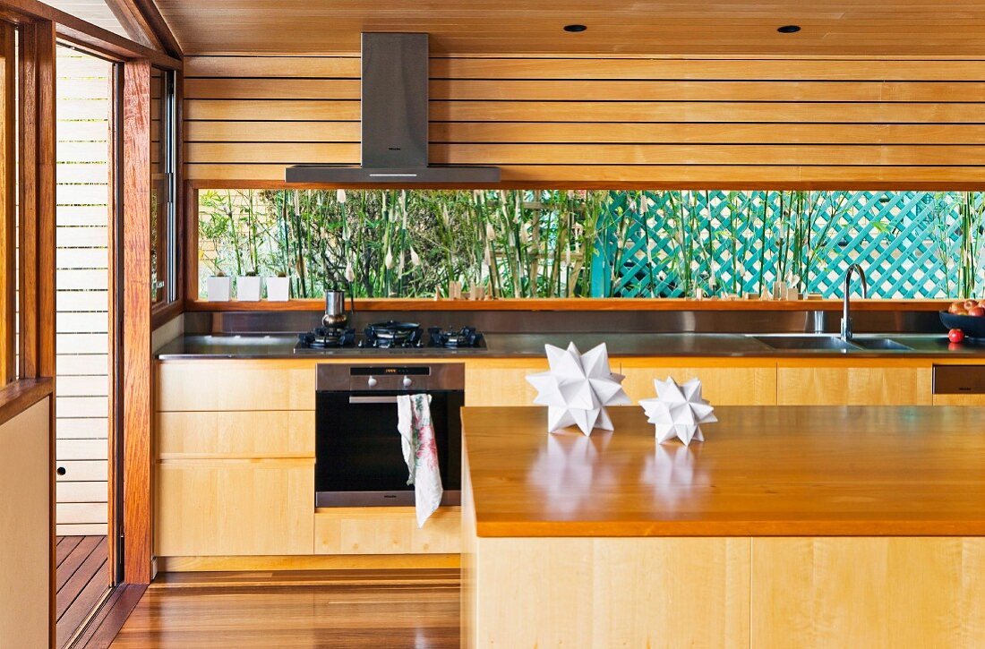 Kücheninsel vor Küchenzeile mit Massivholzfronten in einem Wohnhaus