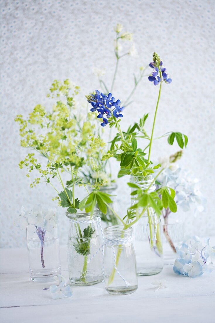 Lupins, lady's mantle, hydrangeas and delphiniums in jars