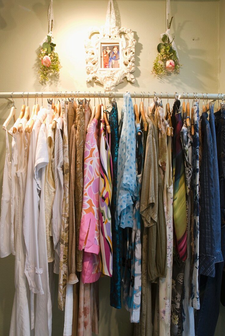 Women's clothing on hangers on wall-mounted clothes rail