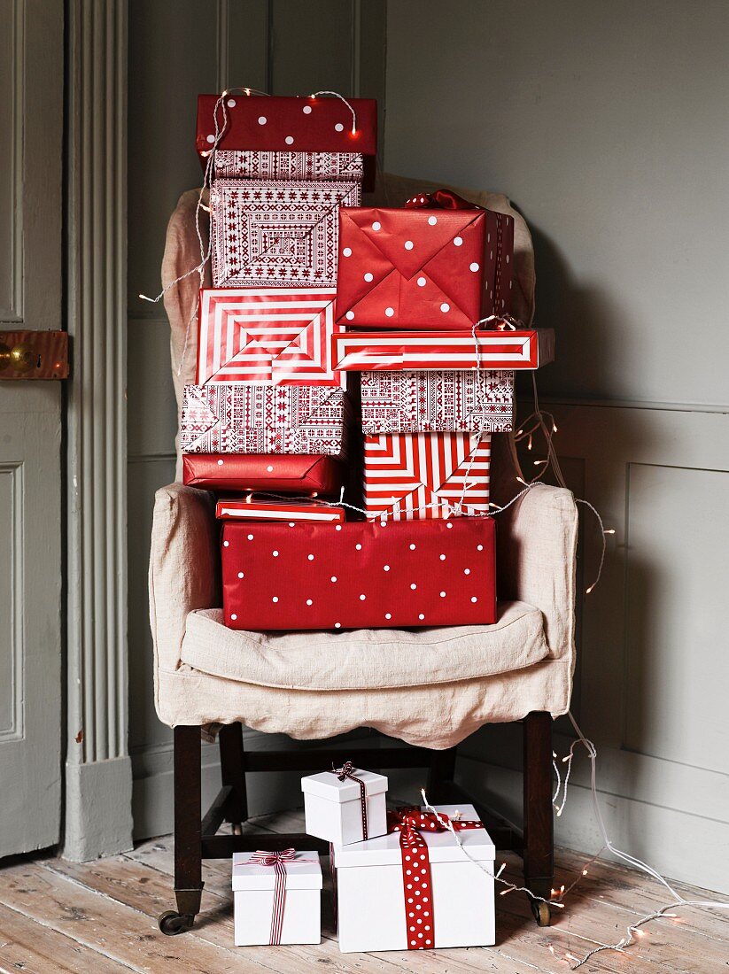 Gifts wrapped in red and white paper on armchair