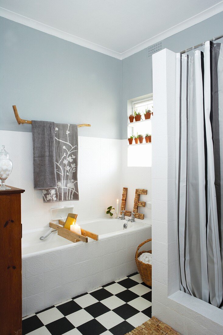 Renoviertes Badezimmer mit schwarz-weiß Schachbrettfliesenboden, grau und weiß abgestufter Wand
