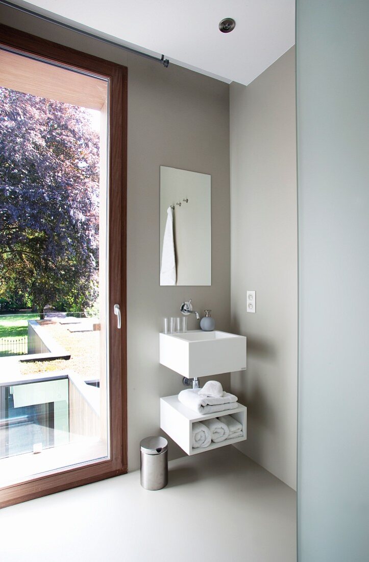 Hellgrau getöntes Designer Badezimmer mit Waschtisch neben Fenstertür