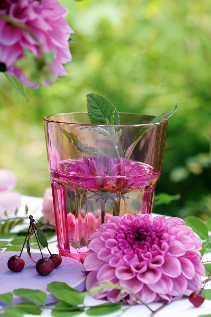 Pinkfarbene Dahlien im Wasserglas als Tischdeko