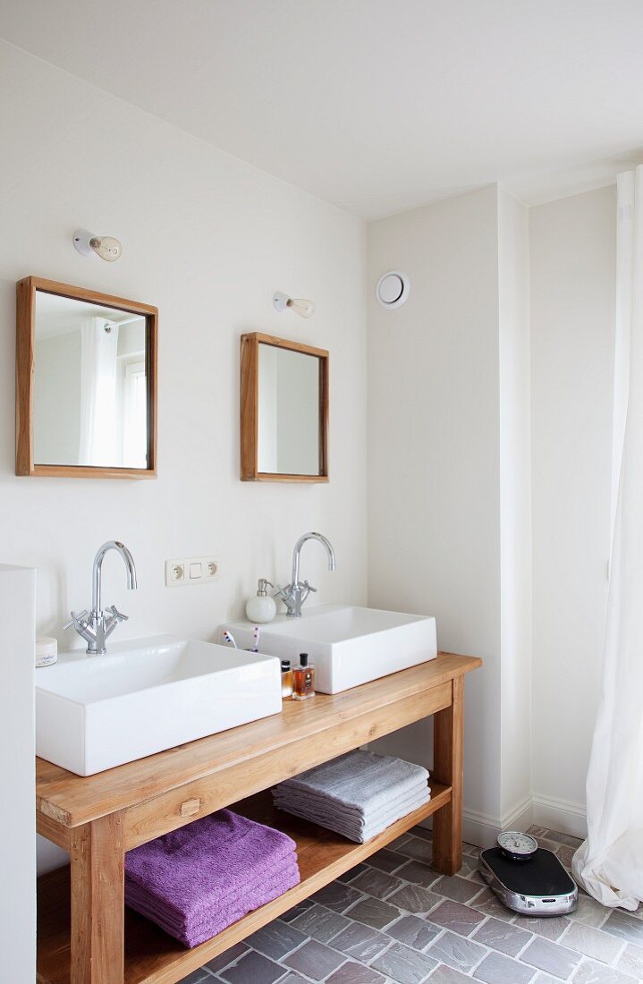 Bathroom with rustic washstand, twin square basins below two square, wood-framed mirrors