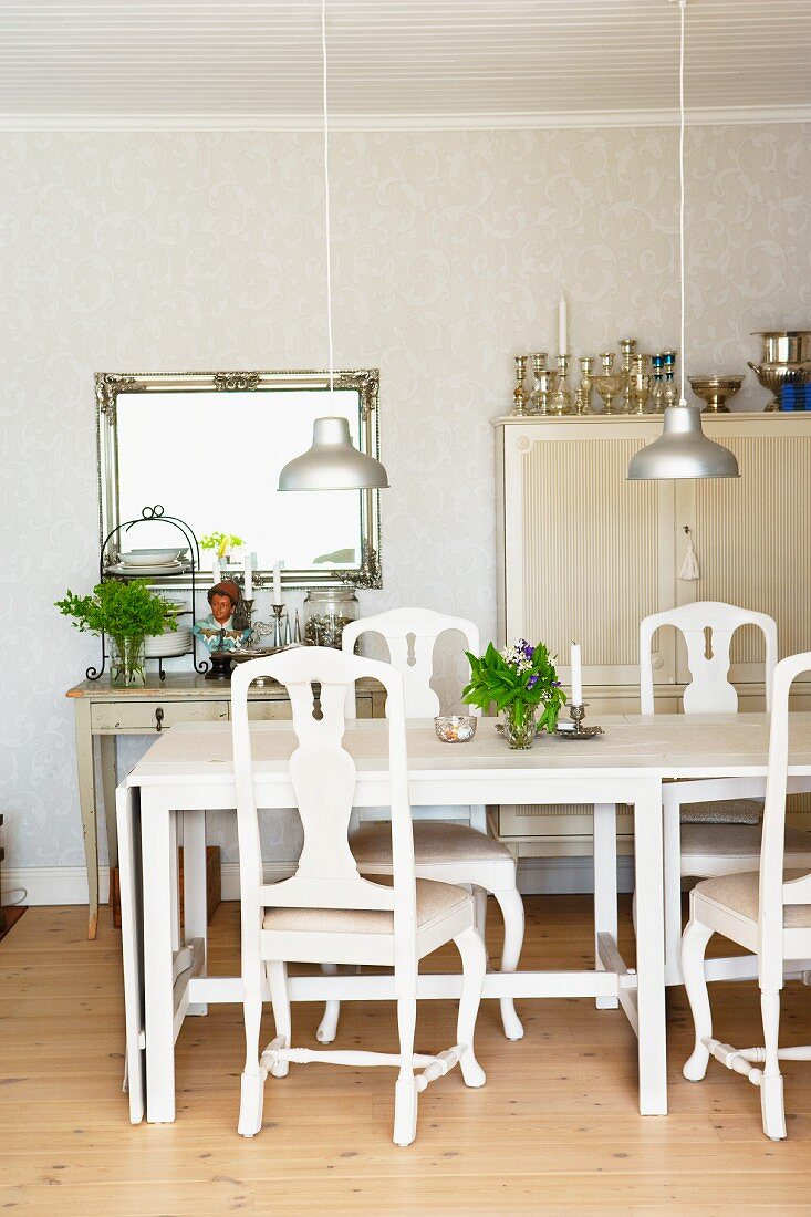 White dining table, chairs and pendant lamps