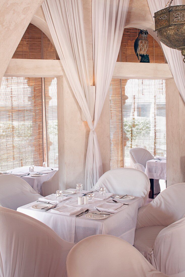 Eleganter Restaurantraum mit weissen Stühlen und Vorhängen im Hotel Raas Haveli, Jodhpur, Indien