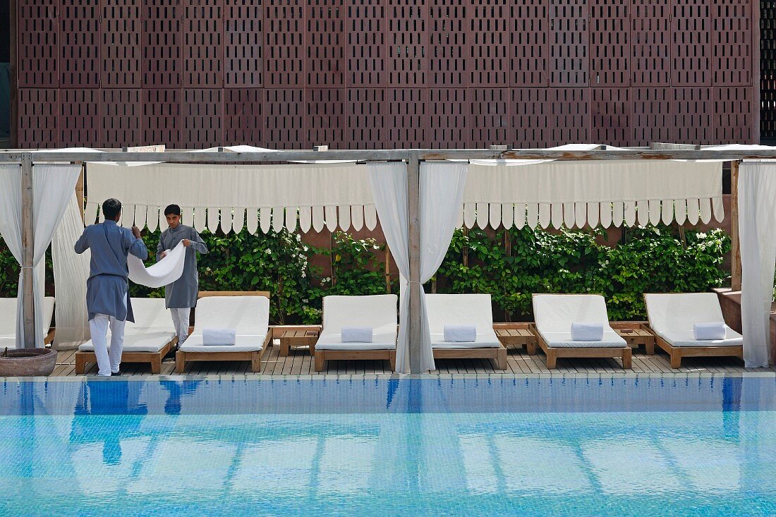 Hotelpersonal arbeitet am luxuriösen Swimmingpool im Hotel Raas Haveli, Jodhpur, Indien