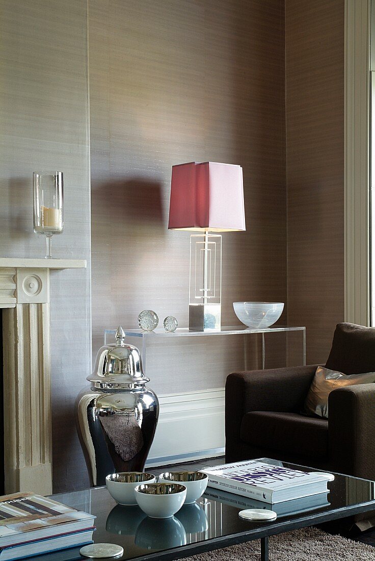 Brauner Polstersessel vor Acrylglasregal mit Art Deco Tischlampe in Wohnzimmerecke