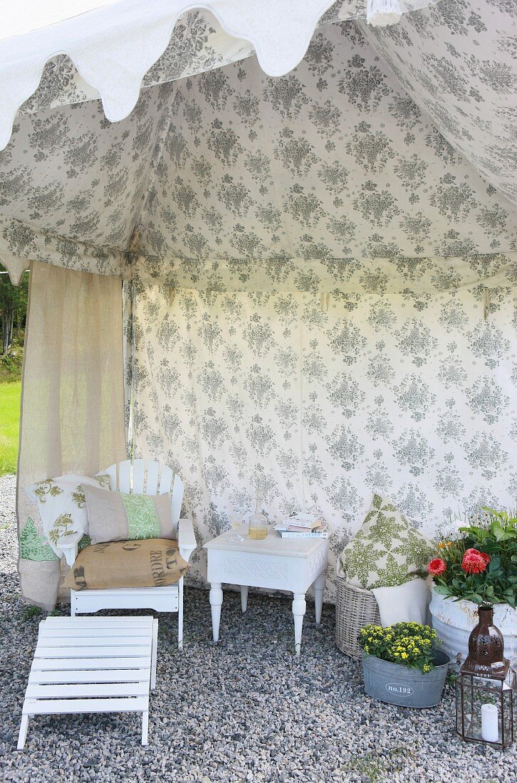 Vintage Gartenmöbel in offenem Zelt mit Blumenmuster an Zeltwandinnenseite