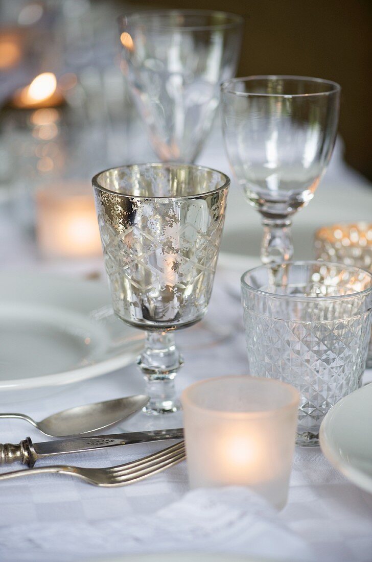 Festively set table with various glasses and tealight holders