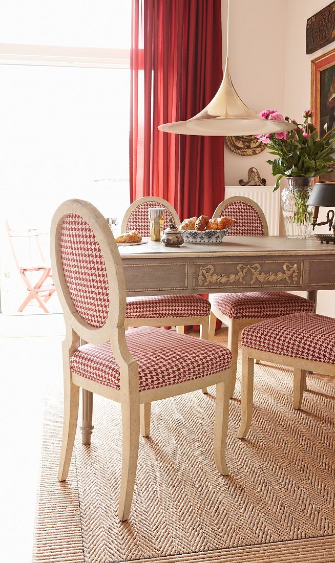 Country-house chairs with red and white houndstooth upholstery on herringbone rug