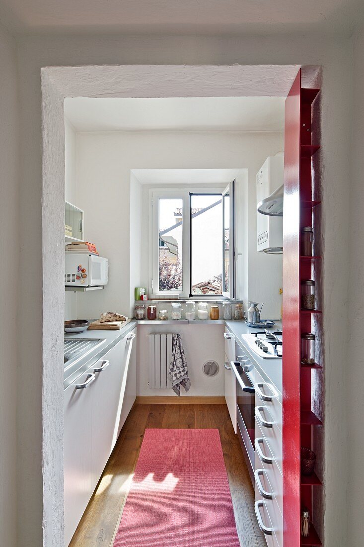 Blick durch offenen Durchgang in schmale, moderne Küche