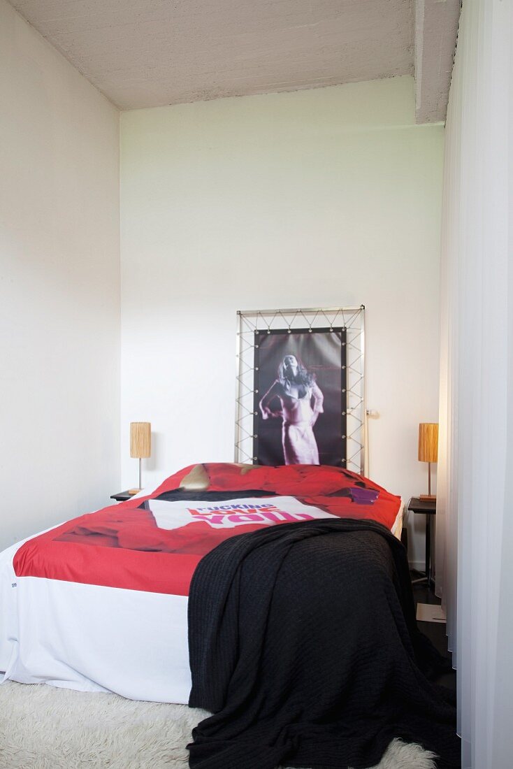 Frauenportrait in Spannrahmen hinter französischem Bett mit poppiger Tagesdecke