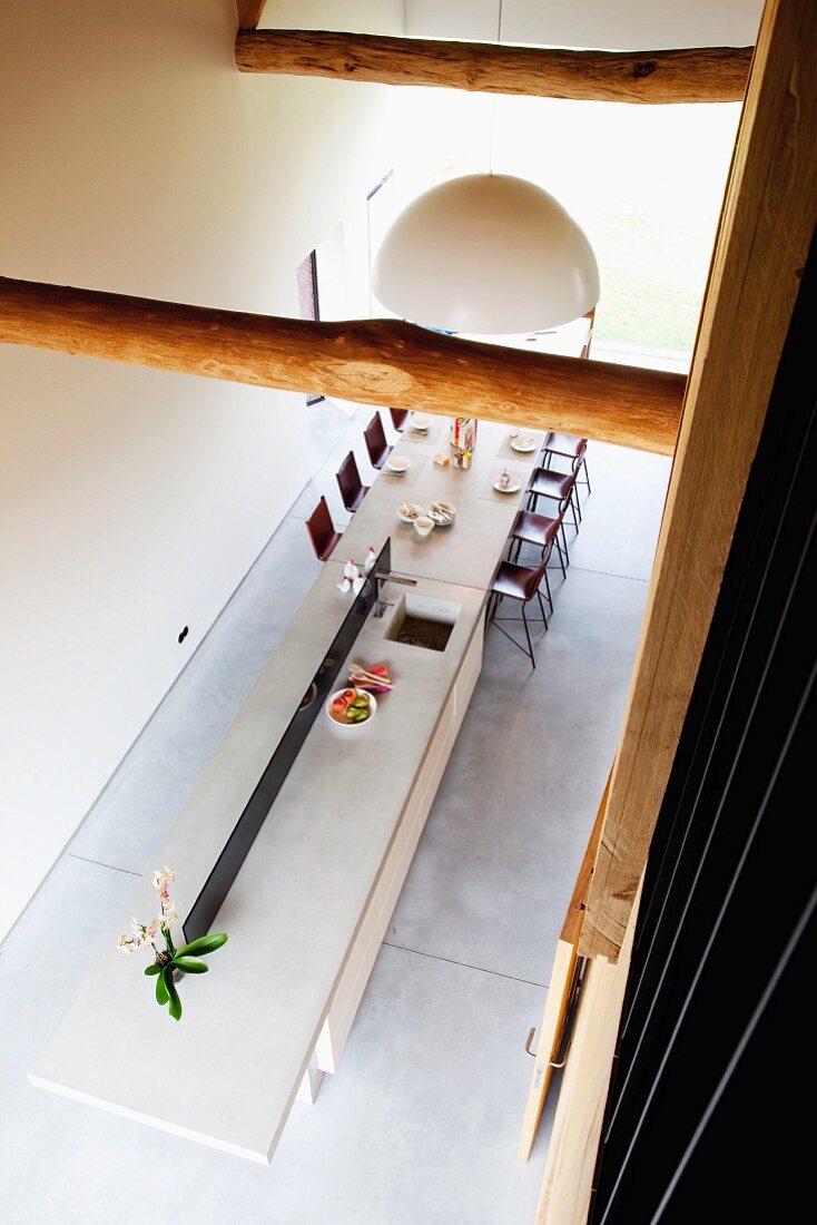 Blick von oben auf lange Esstheke mit Arbeitsfläche und integrierter Spüle im Designerstil