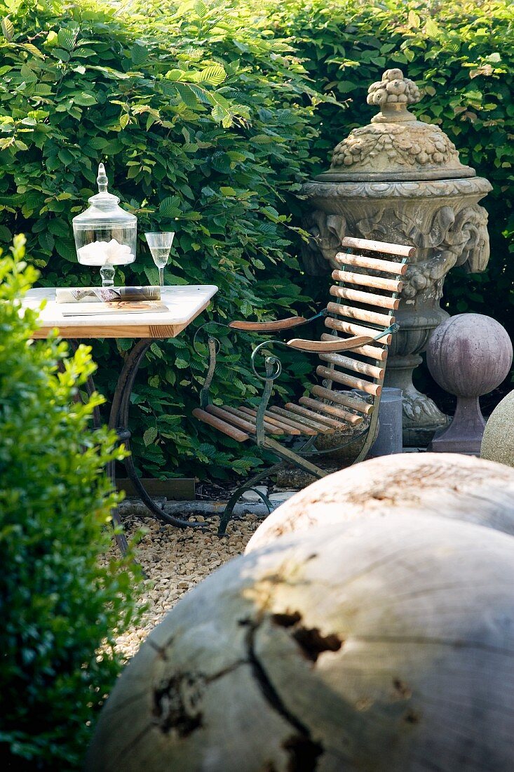 Lauschige Gartenecke mit Tisch und Stuhl zwischen Laubhecken