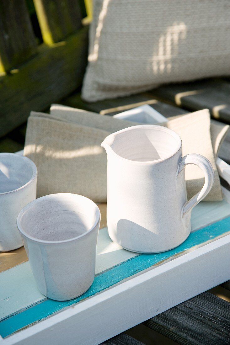 White ceramic jug and beakers on tray
