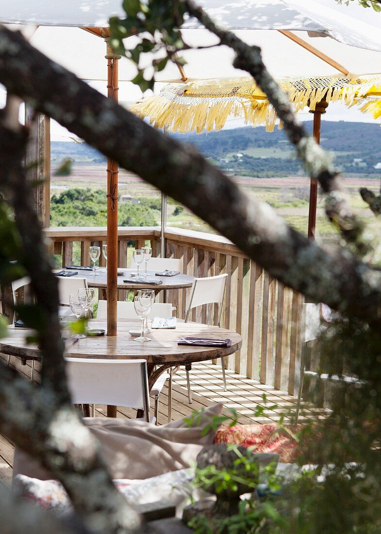 Set table on wooden terrace with view of mountain landscape