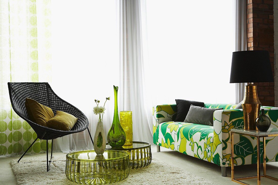 Flowerpower Sofa, Retro Korbstuhl und runde Beistelltische mit Vasendeko