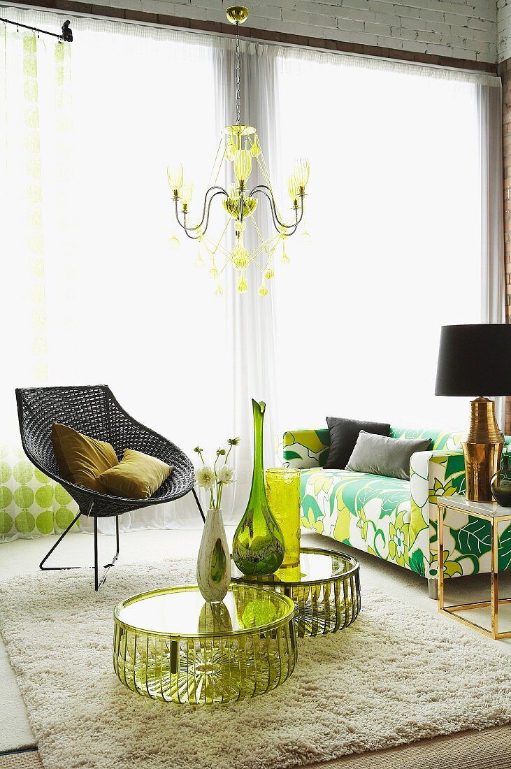 Vases and flowers on plexiglass tables, wicker chair with wire frame and floral, retro, 70s-style sofa