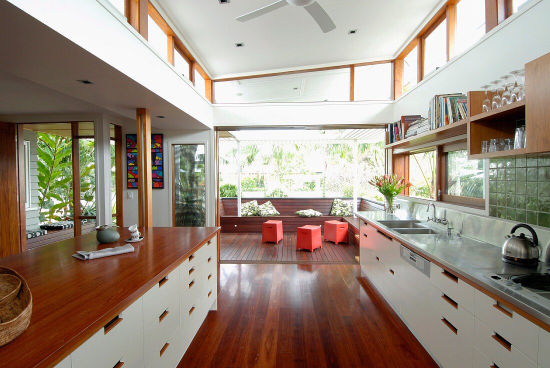 Holz, Edelstahl und weiße Fronten in der offener Küche eines grosszügigen Wohnraums