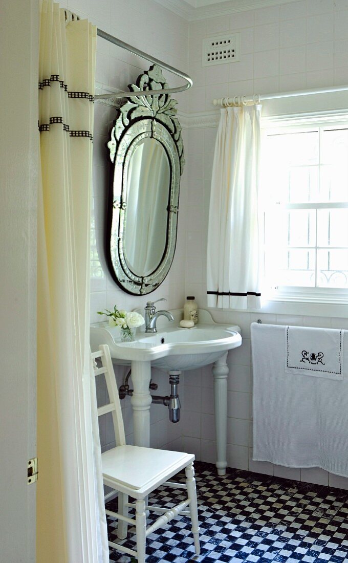 Opulenter Spiegel über Waschbecken in kleinem Bad mit schwarzweissen Bodenfliesen