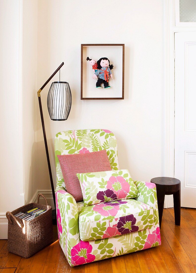 Gemütlicher Sessel mit heiterem Blumenbezug und Retro Stehleuchte in Zimmerecke