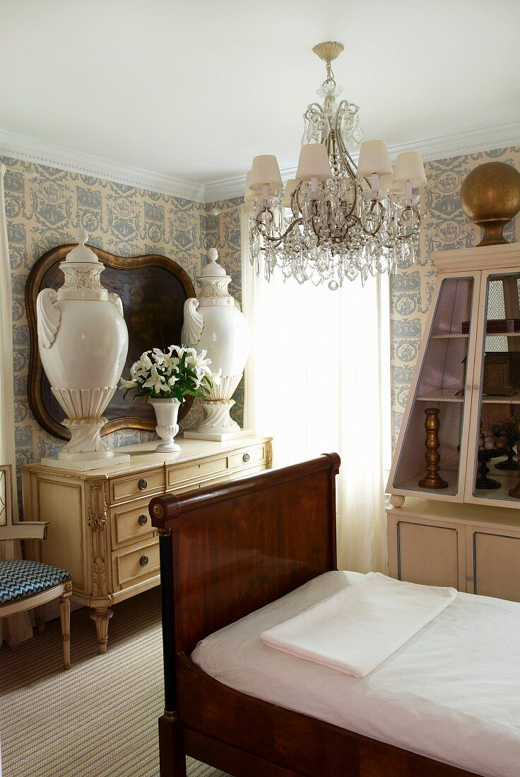 Antikes Bett mit dunklem Holzgestell und Antiquitäten im Gästezimmer