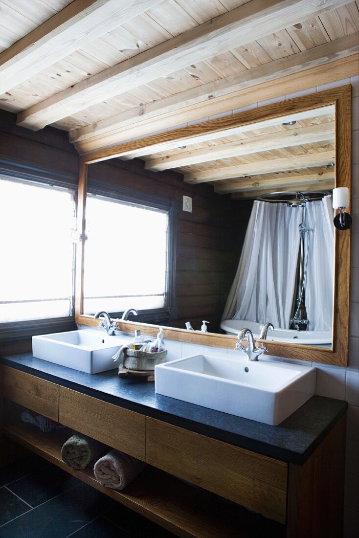 Moderner Waschtisch mit zwei Becken vor gerahmtem Spiegel im Badezimmer mit rustikal modernem Flair