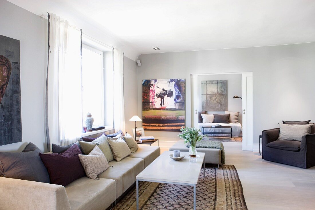 Langes Sofa mit Kissen und Couchtisch auf traditionellem Teppichläufer in modernem Wohnzimmer