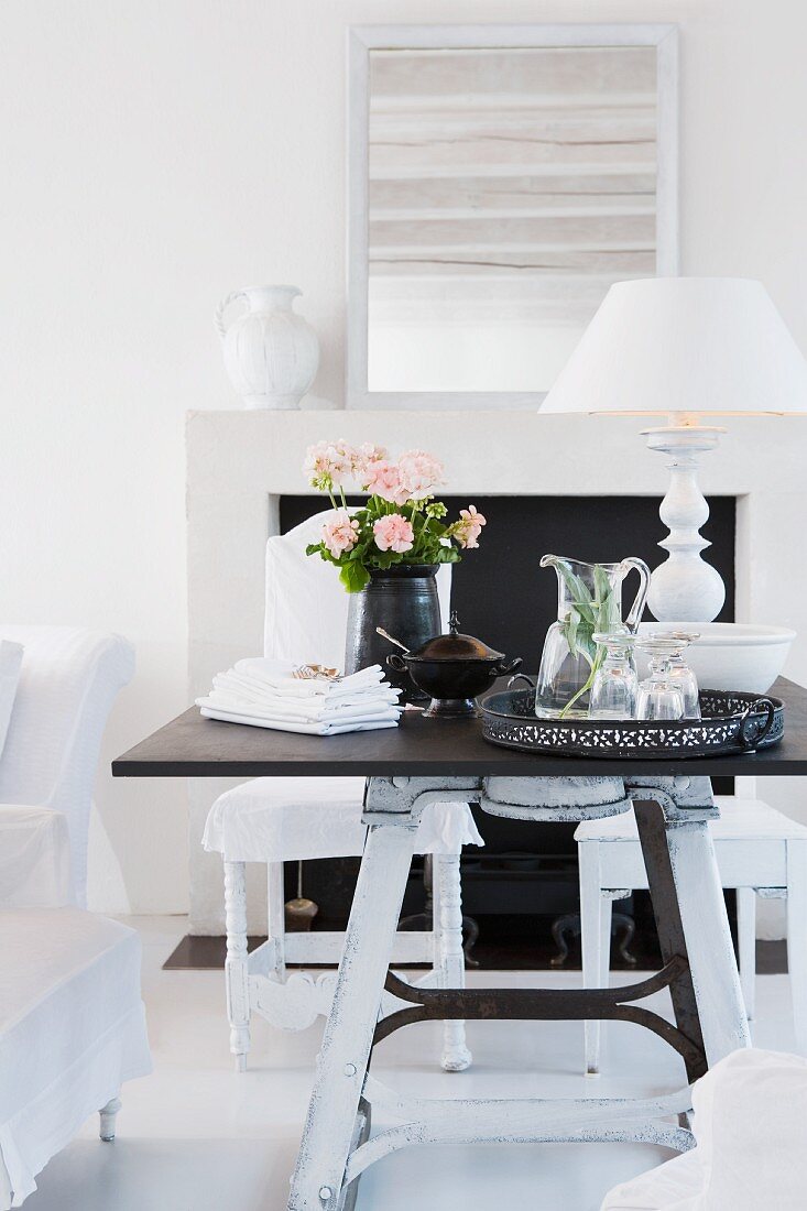Black and white furnishings - tray of refreshing drinks and table lamp with white lampshade on dark tabletop