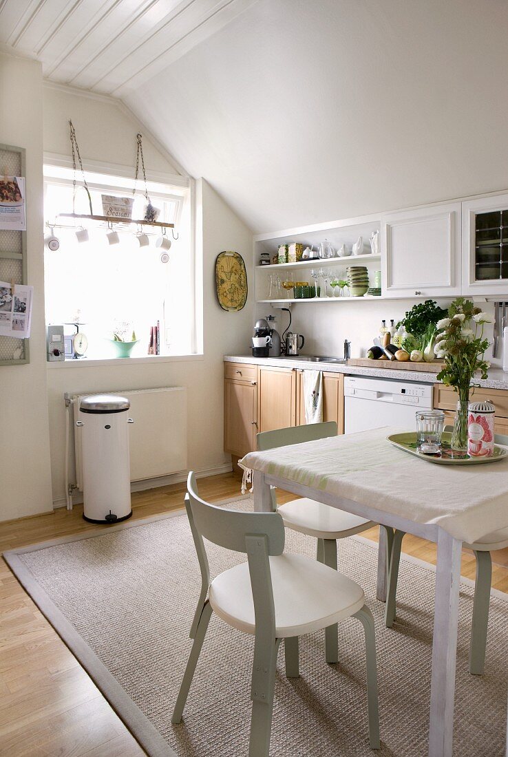 Helle Wohnküche in Weiß mit Naturholzfronten und skandinavischen Stuhlklassikern