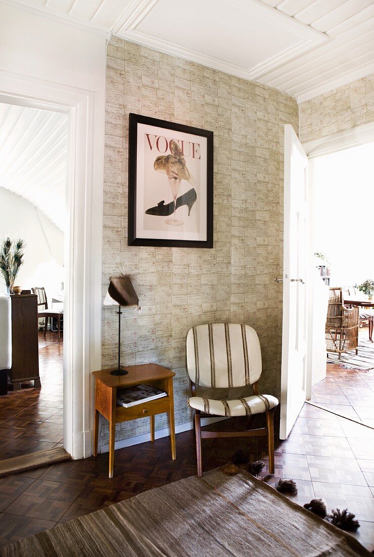 Tapete mit Natursteindesign hinter Stuhl und Telefontisch im Retrostil; Wohnraumdiele mit Blick durch offene Türen