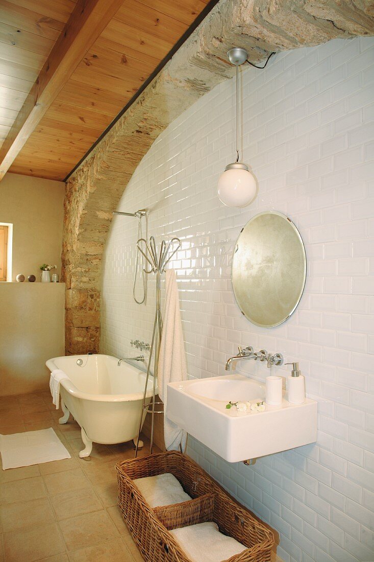 Washbasin and free-standing bathtub in rustic bathroom of Spanish country house