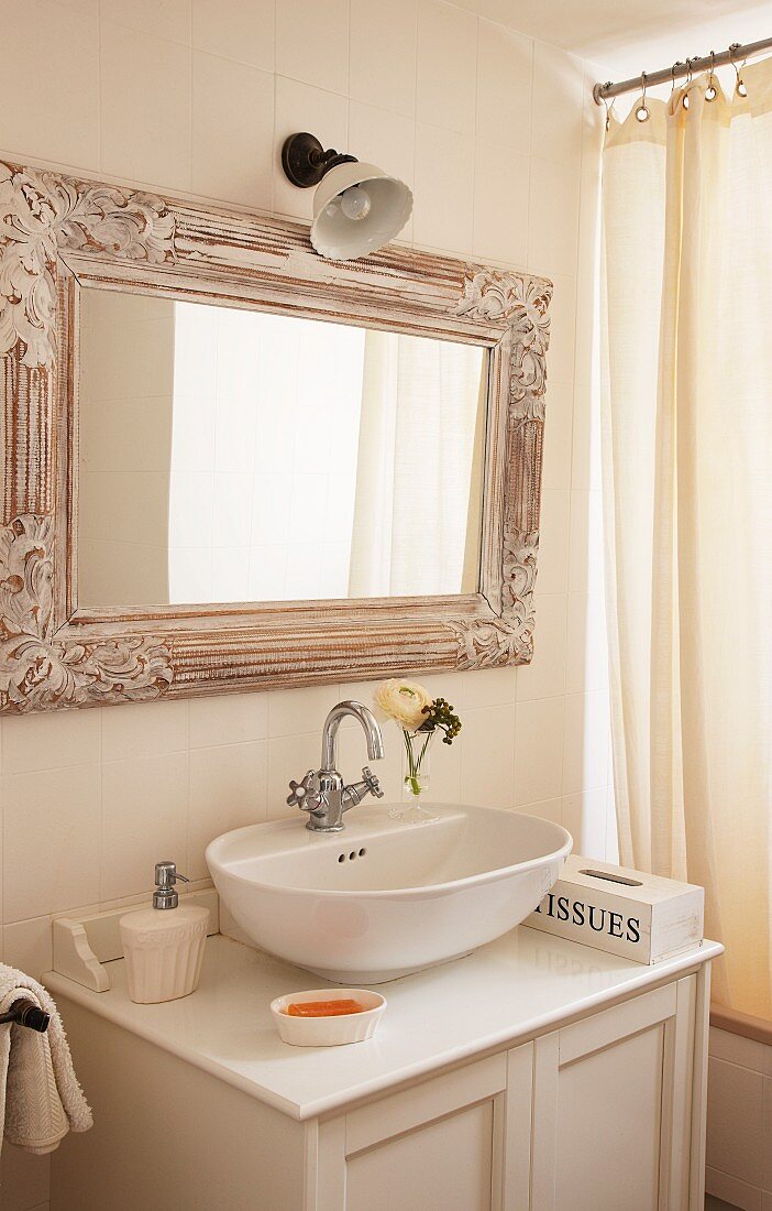 Moderne Waschschüssel auf Vintage Unterschrank und nostalgisch gerahmter Spiegel neben Duschvorhang