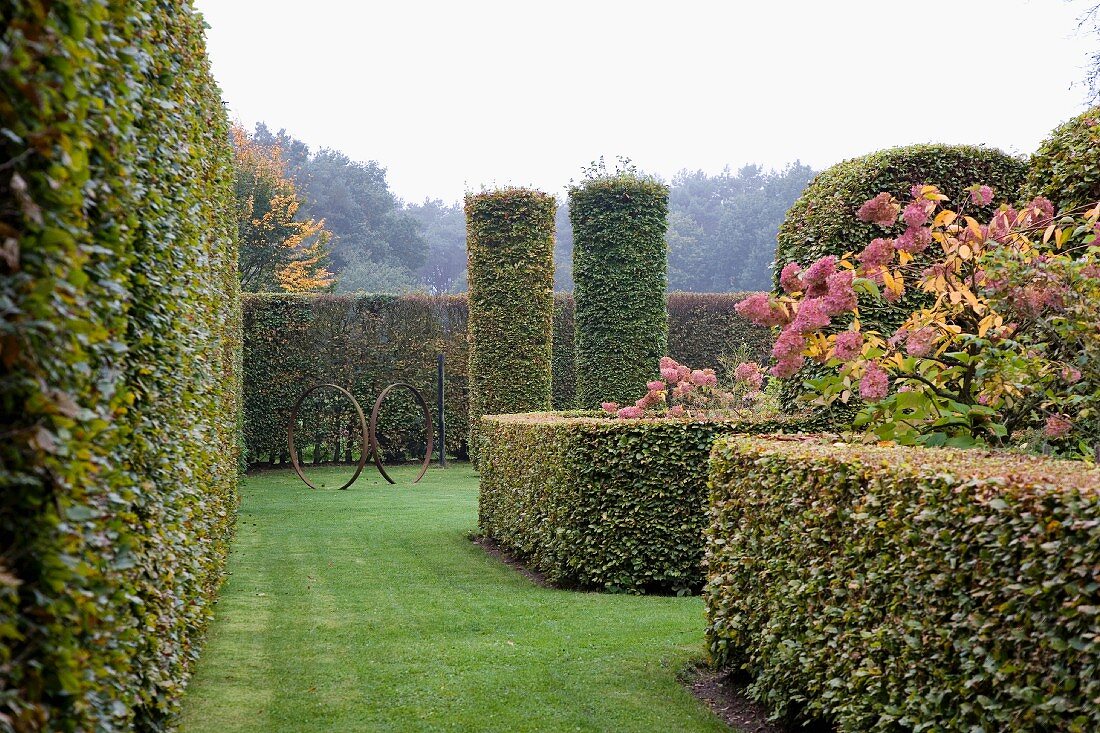 Parkähnliche Gartenanlage mit formgeschnittenen Hecken & zylinderförmig geschnittenen Sträuchern