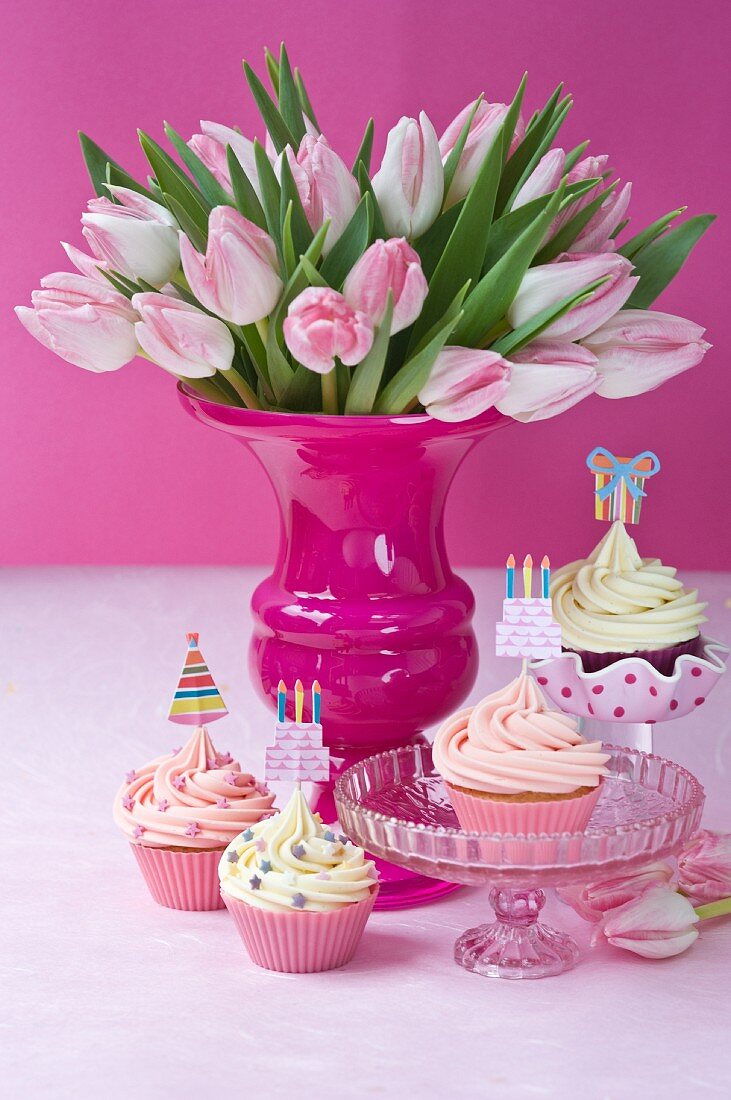 Cupcakes mit Partyfähnchen und ein Tulpenstrauss