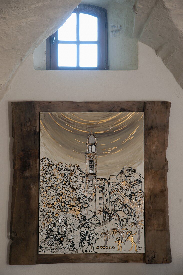 Bild mit Stadtmotiv in rustikalem Rahmen an Wand unter kleinem Fenster mit Sprossen