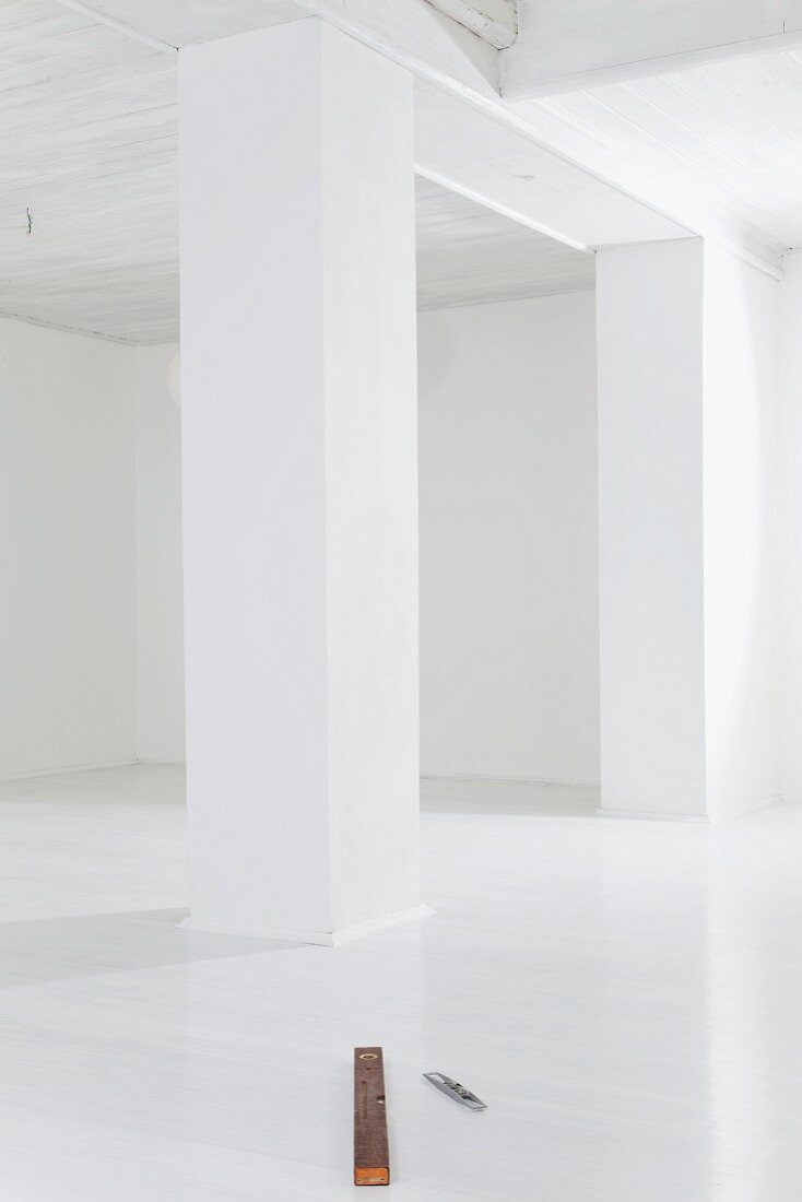 Empty white room with spirit level on floor