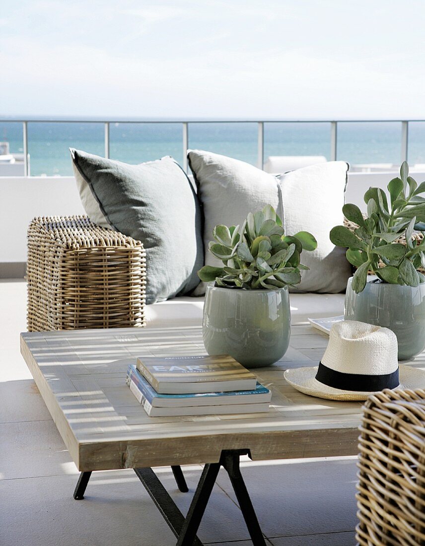 Rattan Sofa und Couchtisch auf Terrasse mit Blick auf das Meer
