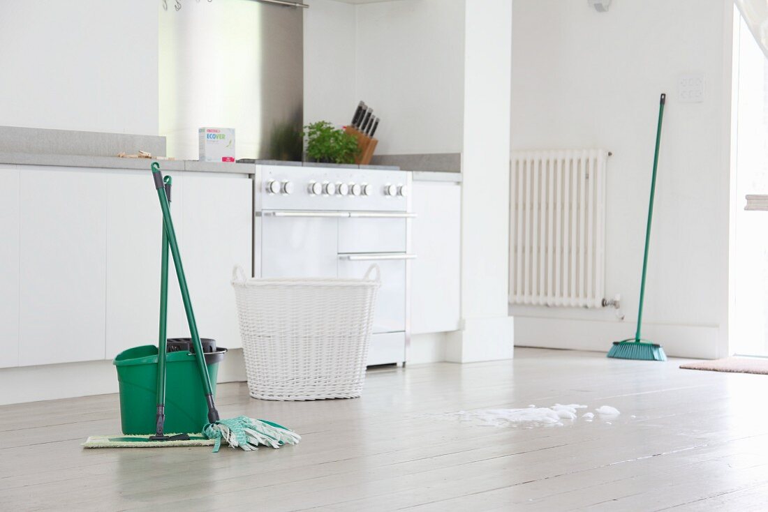 Mops and bucket on white floor in kitchen